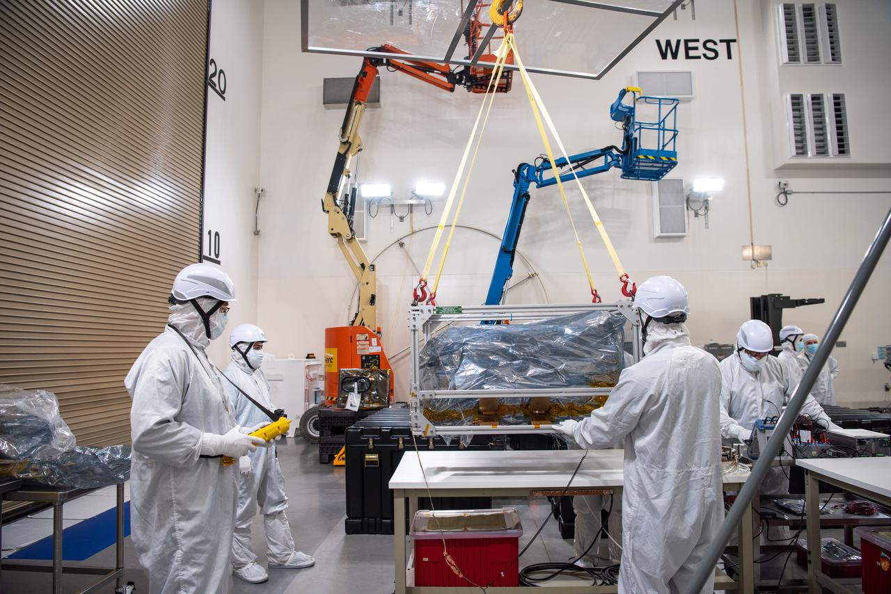 Technicians use an overheard crane to lift NASA’s PUNCH (Polarimeter to Unify the Corona and Heliosphere) spacecraft onto a work stand for testing operations at the Astrotech Processing Facility on Vandenberg Space Force Base in California on Sunday, Jan. 19, 2025. PUNCH, consisting of four satellites, will produce continuous 3D images of the solar wind and solar storms as it travels from the Sun to Earth to better understand how material in the corona accelerates to become the solar wind that fills the solar system. PUNCH will launch aboard a SpaceX Falcon 9 rocket in late February 2025.