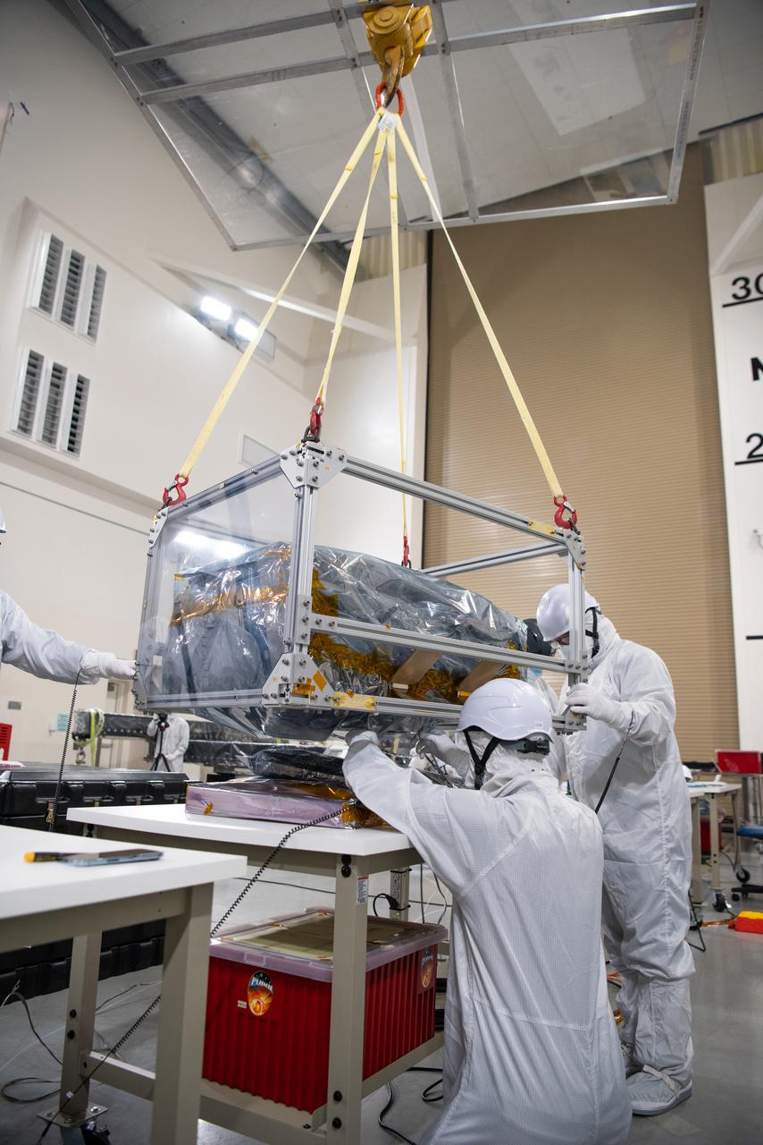 Technicians use an overheard crane to lift NASA’s PUNCH (Polarimeter to Unify the Corona and Heliosphere) spacecraft onto a work stand for testing operations at the Astrotech Processing Facility on Vandenberg Space Force Base in California on Sunday, Jan. 19, 2025. PUNCH, consisting of four satellites, will produce continuous 3D images of the solar wind and solar storms as it travels from the Sun to Earth to better understand how material in the corona accelerates to become the solar wind that fills the solar system. PUNCH will launch aboard a SpaceX Falcon 9 rocket in late February 2025.