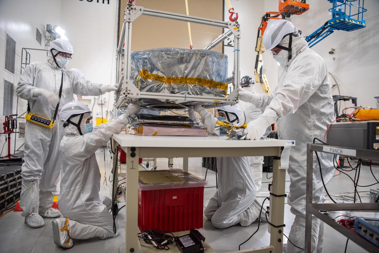 Technicians use an overheard crane to lift NASA’s PUNCH (Polarimeter to Unify the Corona and Heliosphere) spacecraft onto a work stand for testing operations at the Astrotech Processing Facility on Vandenberg Space Force Base in California on Sunday, Jan. 19, 2025. PUNCH, consisting of four satellites, will produce continuous 3D images of the solar wind and solar storms as it travels from the Sun to Earth to better understand how material in the corona accelerates to become the solar wind that fills the solar system. PUNCH will launch aboard a SpaceX Falcon 9 rocket in late February 2025.