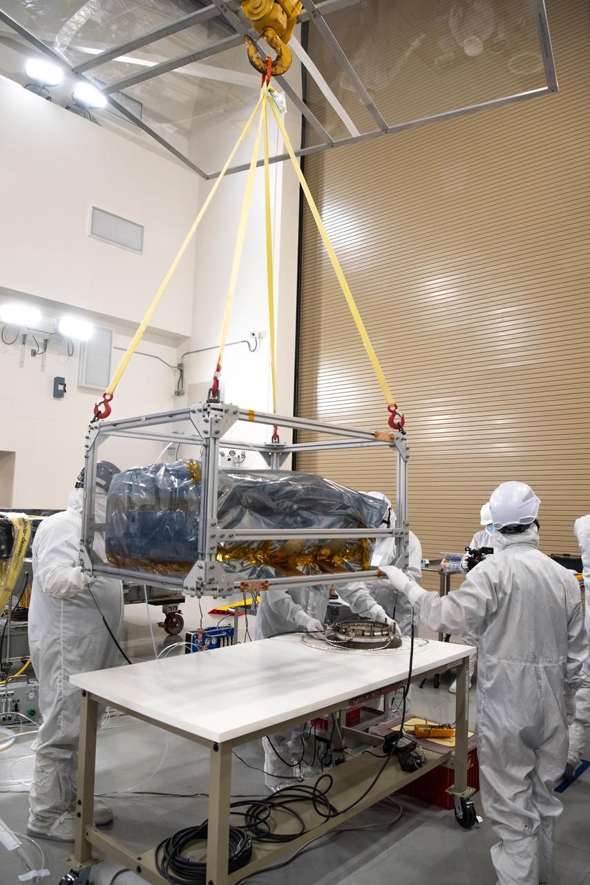Technicians use an overheard crane to lift NASA’s PUNCH (Polarimeter to Unify the Corona and Heliosphere) spacecraft onto a work stand for testing operations at the Astrotech Processing Facility on Vandenberg Space Force Base in California on Sunday, Jan. 19, 2025. PUNCH, consisting of four satellites, will produce continuous 3D images of the solar wind and solar storms as it travels from the Sun to Earth to better understand how material in the corona accelerates to become the solar wind that fills the solar system. PUNCH will launch aboard a SpaceX Falcon 9 rocket in late February 2025.