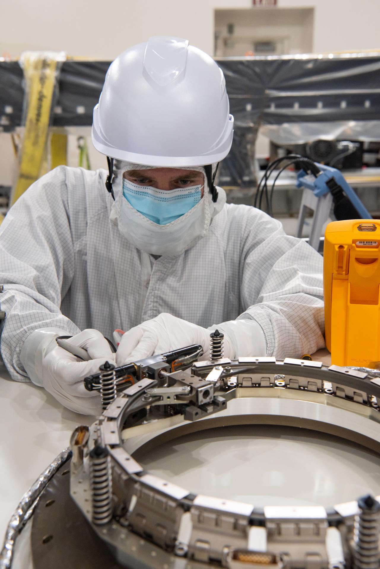 Technicians conduct testing operations on NASA’s PUNCH (Polarimeter to Unify the Corona and Heliosphere) spacecraft onto a work stand for testing operations at the Astrotech Processing Facility on Vandenberg Space Force Base in California on Sunday, Jan. 19, 2025. PUNCH, consisting of four satellites, will produce continuous 3D images of the solar wind and solar storms as it travels from the Sun to Earth to better understand how material in the corona accelerates to become the solar wind that fills the solar system. PUNCH will launch aboard a SpaceX Falcon 9 rocket in late February 2025.