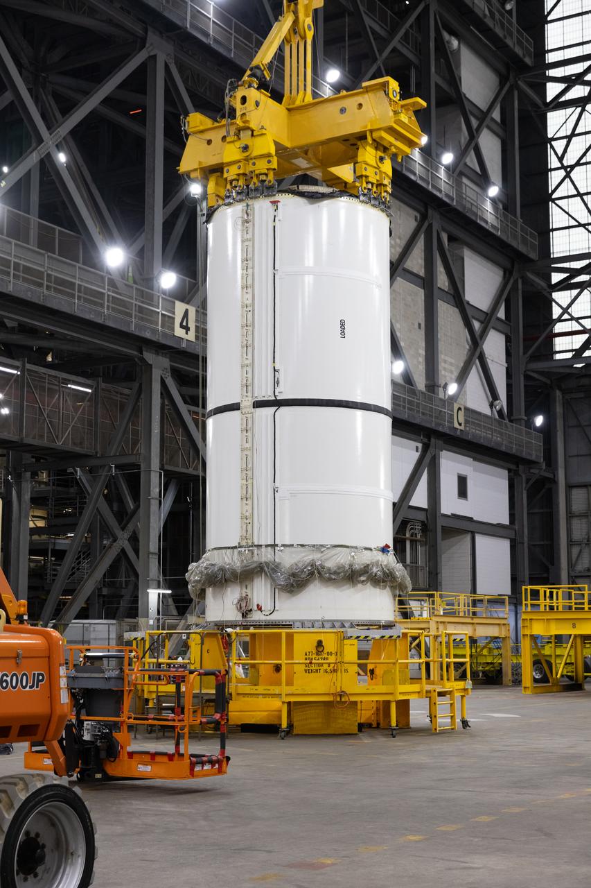 Engineers and technicians with NASA's Exploration Ground Systems Program transfer the right forward center segment to the Vehicle Assembly Building at NASA's Kennedy Space Center in Florida. The booster segment is shown attached to a lifting beam on Tuesday, Jan. 21, 2025 ahead of integration onto the Mobile Launcher 1. The boosters will help support the remaining rocket components and the Orion spacecraft during final assembly of the Artems II Moon rocket and provide more than 75 percent of the total SLS (Space Launch System) thrust during liftoff from NASA Kennedy's Launch Pad 39B.
