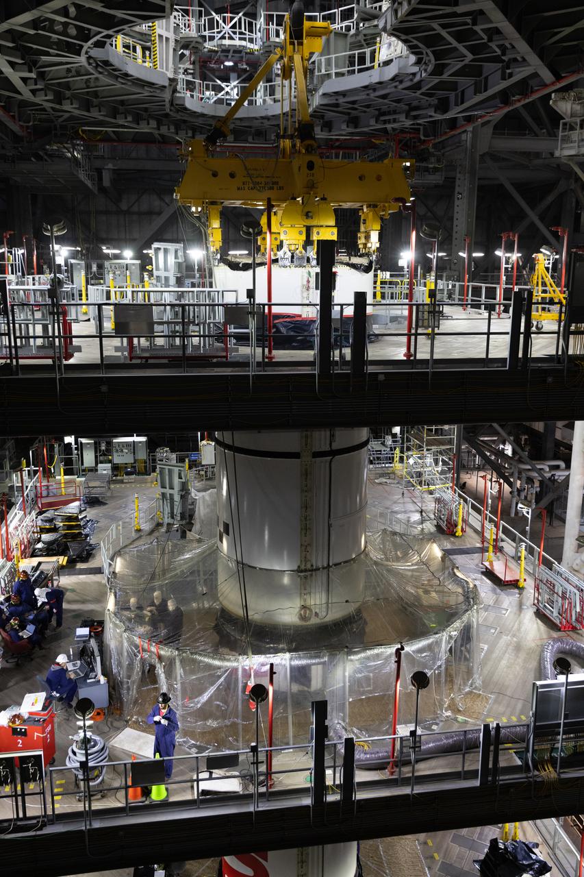 Engineers and technicians with NASA's Exploration Ground Systems Program transfer the right forward center segment to the Vehicle Assembly Building at NASA's Kennedy Space Center in Florida. The booster segment is shown attached to a lifting beam on Tuesday, Jan. 22, 2025 ahead of integration onto the Mobile Launcher 1. The boosters will help support the remaining rocket components and the Orion spacecraft during final assembly of the Artems II Moon rocket and provide more than 75 percent of the total SLS (Space Launch System) thrust during liftoff from NASA Kennedy's Launch Pad 39B.