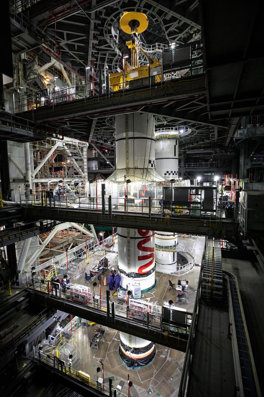 Inside High Bay 3 of the Vehicle Assembly Building at NASA’s Kennedy Space Center in Florida, technicians with the agency’s Exploration Ground Systems use a crane to lower the left forward center booster segment for the NASA’s SLS (Space Launch System) rocket onto the left center center segment atop the mobile launcher on Thursday, Jan. 30, 2025. The NASA “worm” insignia can be seen on both the center center booster segments. The boosters will help support the remaining rocket components and the Orion spacecraft during final assembly of the Artemis II Moon rocket and provide more than 75 percent of the total SLS thrust during liftoff from NASA Kennedy’s Launch Pad 39B.