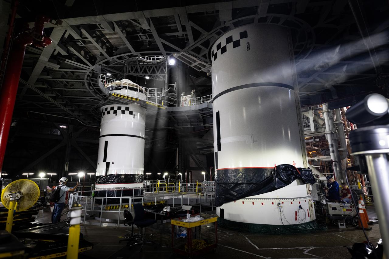 Technicians with Exploration Ground Systems integrate the right forward segment atop the center forward segment on NASA’s SLS (Space Launch System) Moon rocket booster inside the Vehicle Assembly Building’s High Bay 3 at Kennedy Space Center in Florida on Friday, Feb. 14, 2025. The twin solid boosters, five segments on each side, will help support the remaining rocket components and the Orion spacecraft during final assembly of the Artemis II Moon rocket and provide more than 75 percent of the total SLS thrust during liftoff from NASA Kennedy’s Launch Pad 39B.