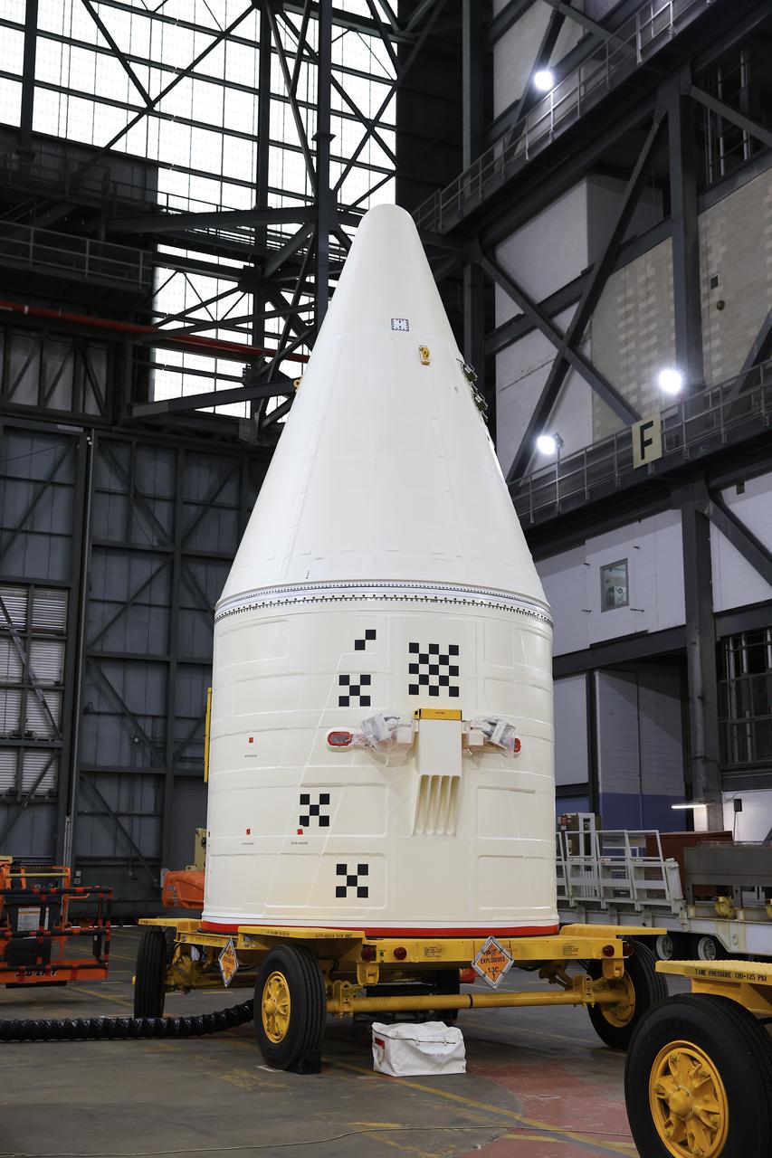 Engineers with NASA’s Exploration Ground Systems integrate the aerodynamic nose cone onto the right-hand forward assembly of the twin SLS (Space Launch System) solid rocket boosters for Artemis II inside the Vehicle Assembly Building’s High Bay 3 at NASA’s Kennedy Space Center in Florida on Tuesday, Feb. 18, 2025. Each forward assembly contains an aerodynamic top, a forward skirt housing avionics, and frustum housing motors that allow the boosters to separate from the SLS core stage after launch. The twin solid boosters will help support the remaining rocket components and the Orion spacecraft during final assembly of the Artemis II Moon rocket and provide more than 75 percent of the total SLS thrust during liftoff from NASA Kennedy’s Launch Pad 39B.