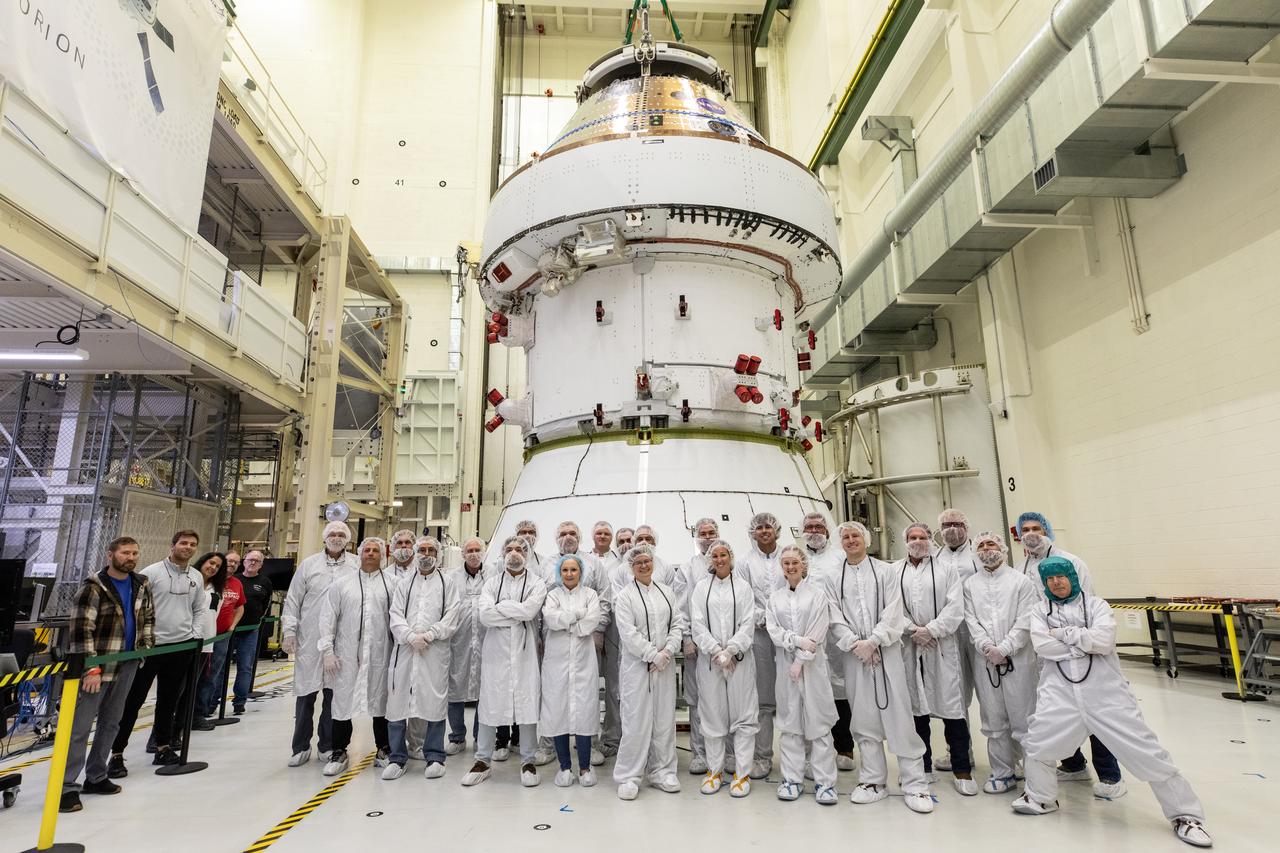 Crews with NASA and Lockheed Martin pose for a photo in front of NASA’s Artemis II Orion spacecraft inside the Neil A. Operations and Checkout Building at NASA’s Kennedy Space Center in Florida on Saturday, Feb. 22, 2025. Technicians operated a 30-ton crane to move the spacecraft from  the Final Assembly and System Testing cell to prepare for upcoming installation of four solar array wings and spacecraft adapter jettison fairings for the agency’s first crewed flight test under the Artemis campaign.