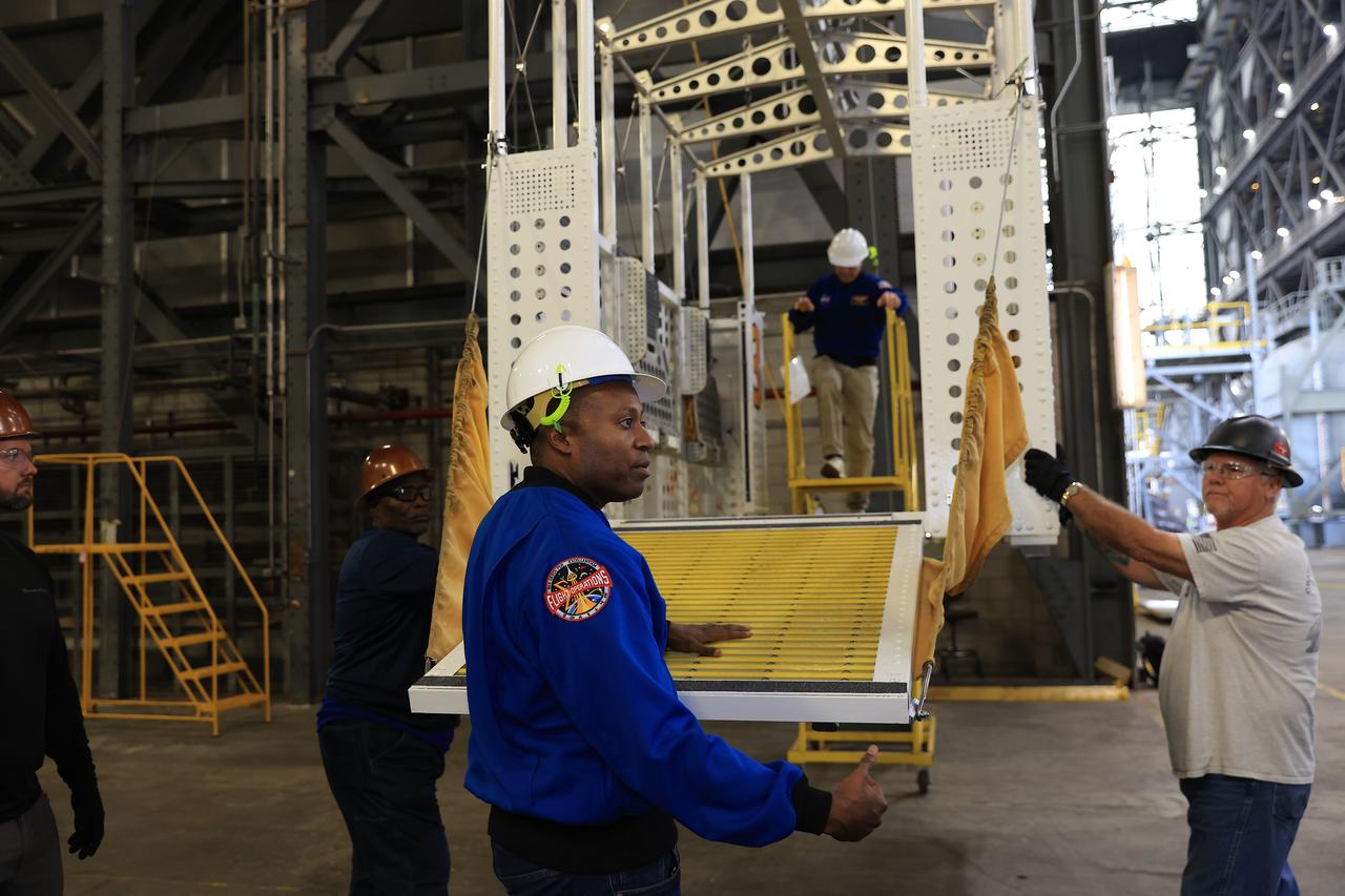 From left, NASA astronauts Andre Douglas, Artemis II backup crew member and Artemis II astronaut Reid Wiseman, commander, practice climbing into an emergency egress basket inside the Vehicle Assembly Building at NASA’s Kennedy Space Center in Florida on Thursday, Feb. 27, 2025. The baskets, similar to gondolas on ski lifts, are used in the case of a pad abort emergency to enable astronauts and other pad personnel a way to quickly escape away from the mobile launcher to the base of the pad and where waiting emergency transport vehicles will then drive them away. For Artemis II, four astronauts will venture around the Moon, the first crewed mission on NASA’s path to establishing a long-term presence for science and exploration through Artemis. 
