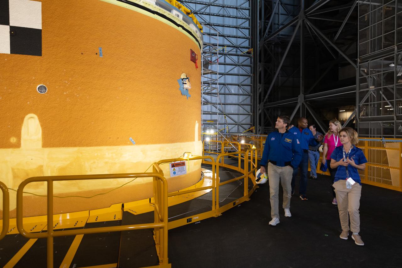 From left, Artemis II NASA astronauts Reid Wiseman, commander; Artemis II backup crew member Andre Douglas; and Artemis team members view the SLS (Space Launch System) core stage inside the Vehicle Assembly Building at NASA Kennedy’s Space Center in Florida on Thursday, Feb. 27, 2025. The core stage has two giant propellant tanks that collectively hold more than 733,000 gallons of super cold liquid propellant to feed the stage’s four RS-25 engines to help send astronauts inside NASA’s Orion spacecraft to venture around the Moon for Artemis II.