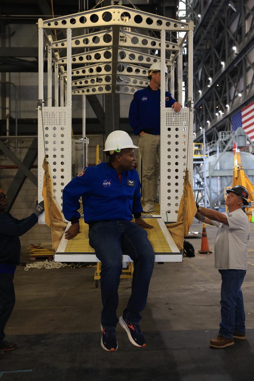 From left, NASA astronauts Andre Douglas, Artemis II backup crew member and Artemis II astronaut Reid Wiseman, commander, practice climbing into an emergency egress basket inside the Vehicle Assembly Building at NASA’s Kennedy Space Center in Florida on Thursday, Feb. 27, 2025. The baskets, similar to gondolas on ski lifts, are used in the case of a pad abort emergency to enable astronauts and other pad personnel a way to quickly escape away from the mobile launcher to the base of the pad and where waiting emergency transport vehicles will then drive them away. For Artemis II, four astronauts will venture around the Moon, the first crewed mission on NASA’s path to establishing a long-term presence for science and exploration through Artemis.