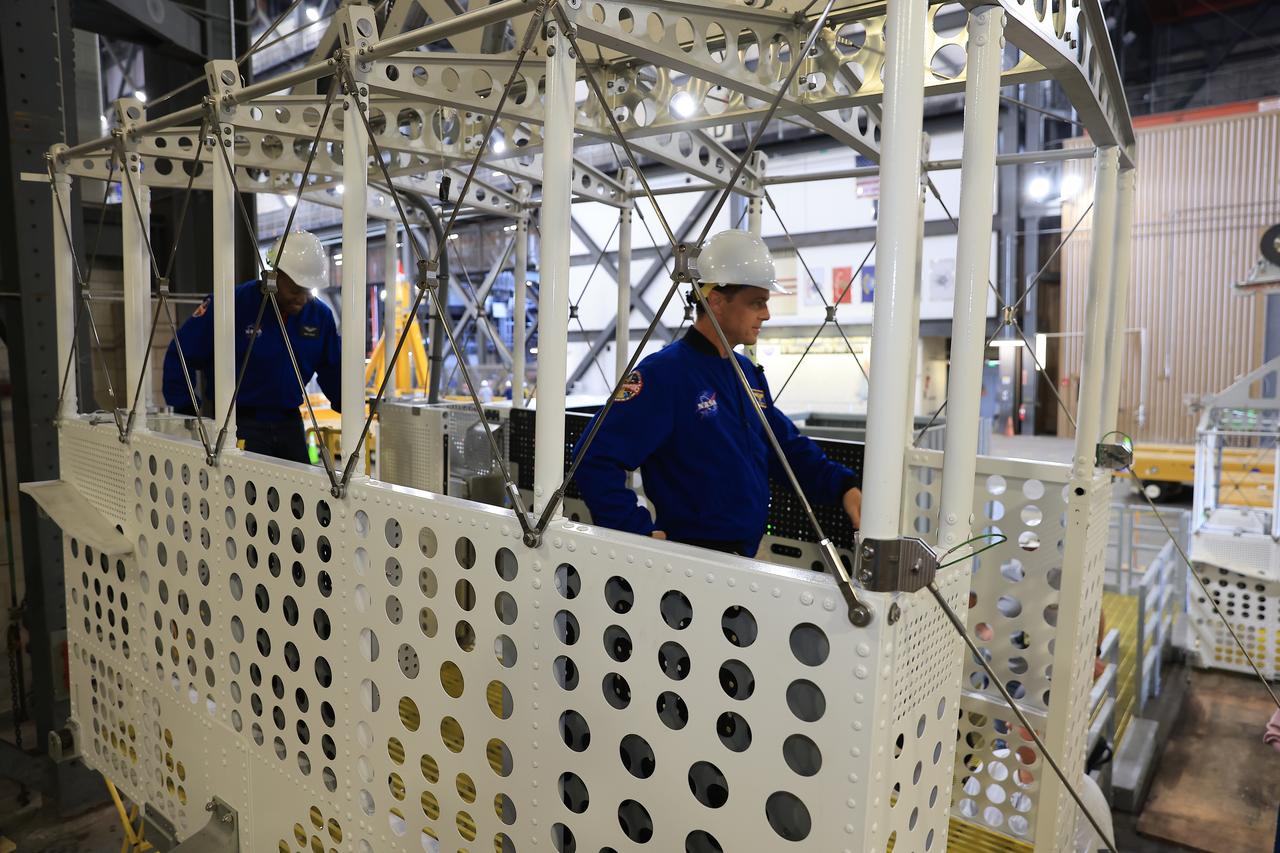 From left, NASA astronauts Andre Douglas, Artemis II backup crew member and Artemis II astronaut Reid Wiseman, commander, practice climbing into an emergency egress basket inside the Vehicle Assembly Building at NASA’s Kennedy Space Center in Florida on Thursday, Feb. 27, 2025. The baskets, similar to gondolas on ski lifts, are used in the case of a pad abort emergency to enable astronauts and other pad personnel a way to quickly escape away from the mobile launcher to the base of the pad and where waiting emergency transport vehicles will then drive them away. For Artemis II, four astronauts will venture around the Moon, the first crewed mission on NASA’s path to establishing a long-term presence for science and exploration through Artemis.
