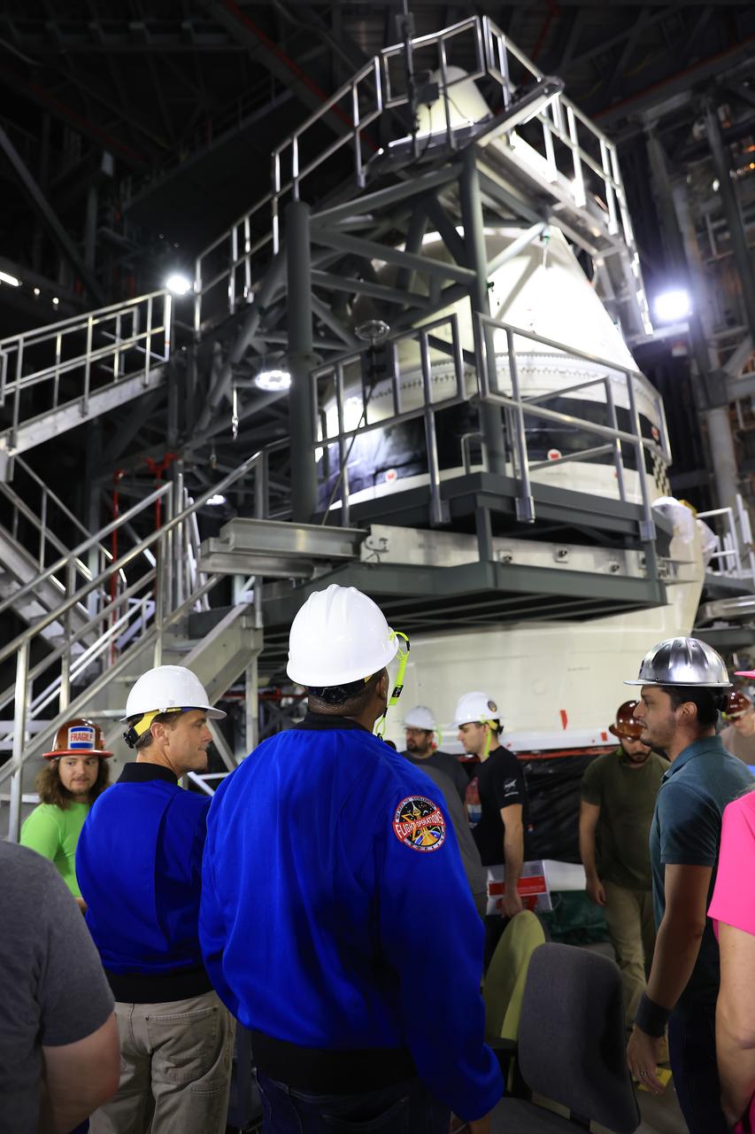 From left, NASA astronauts Andre Douglas, Artemis II backup crew member, and Artemis II astronaut Reid Wiseman, commander; and Artemis team members tour the twin SLS (Space Launch System) solid rocket boosters for Artemis II inside the Vehicle Assembly Building at NASA Kennedy on Thursday, Feb. 27, 2025. For Artemis II, four astronauts will venture around the Moon, the first crewed mission on NASA’s path to establishing a long-term presence for science and exploration through Artemis.