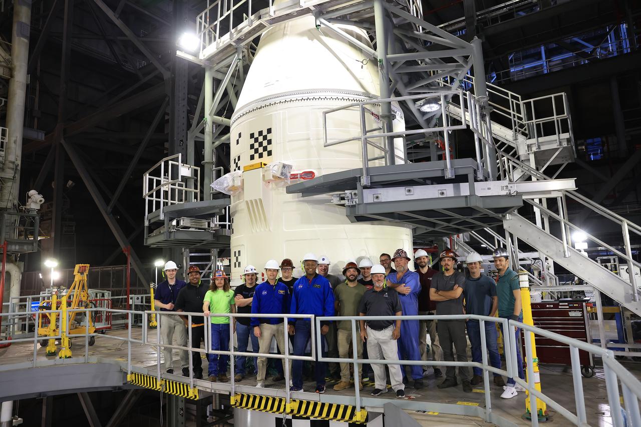 NASA astronauts Andre Douglas, Artemis II backup crew member; Artemis II astronaut Reid Wiseman, commander; and Artemis team members, pose for a photo in front of the twin SLS (Space Launch System) solid rocket boosters for Artemis II inside the Vehicle Assembly Building at NASA Kennedy on Thursday, Feb. 27, 2025. For Artemis II, four astronauts will venture around the Moon, the first crewed mission on NASA’s path to establishing a long-term presence for science and exploration through Artemis.