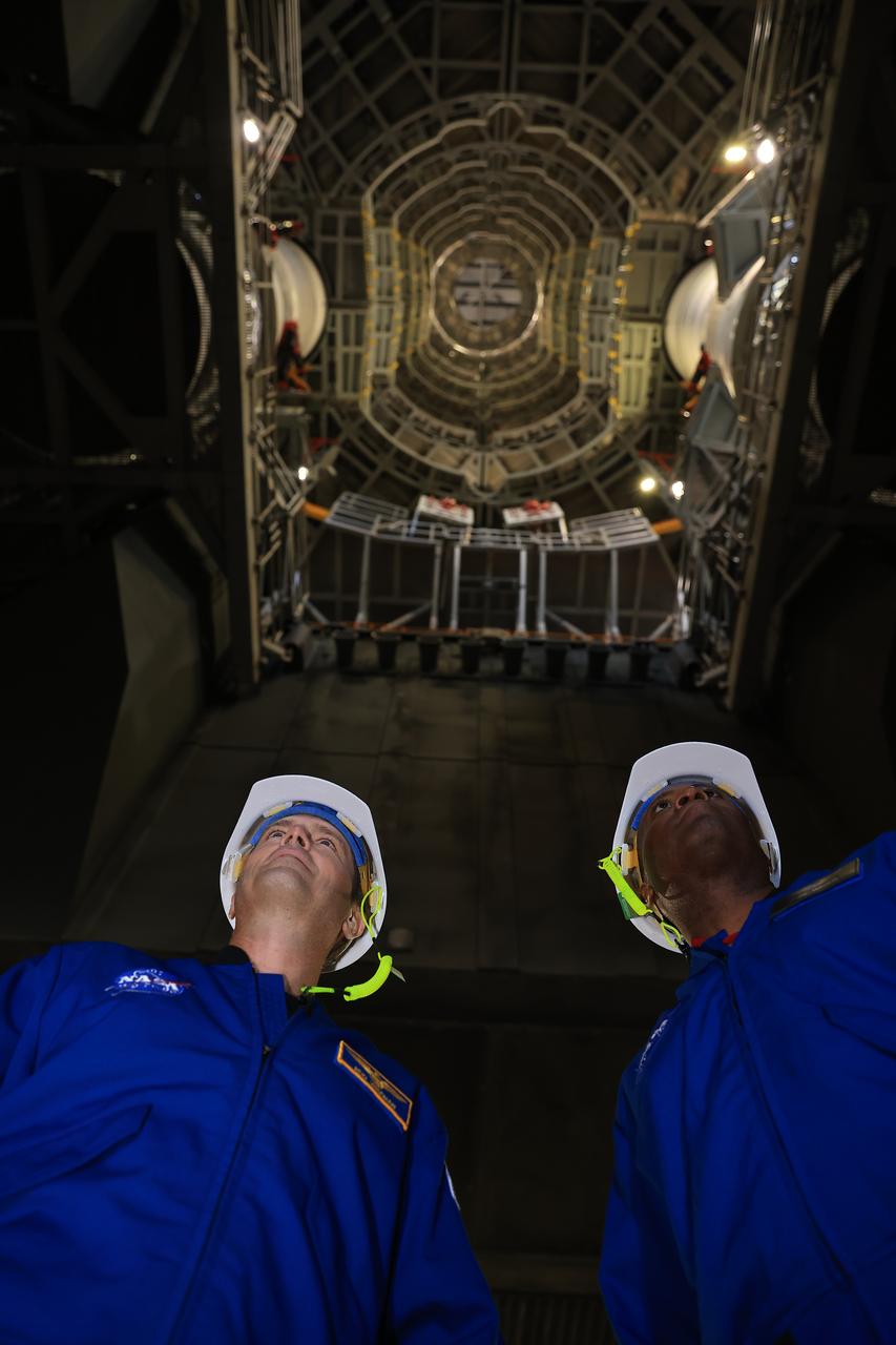 A photographer captures NASA astronauts Reid Wiseman, Artemis II commander, and Andre Douglas, Artemis II backup crew member, standing underneath mobile launcher 1 with the integrated the twin SLS (Space Launch System) solid rocket boosters for Artemis II inside the Vehicle Assembly Building at NASA Kennedy on Thursday, Feb. 27, 2025. For Artemis II, four astronauts will venture around the Moon, the first crewed mission on NASA’s path to establishing a long-term presence for science and exploration through Artemis. 