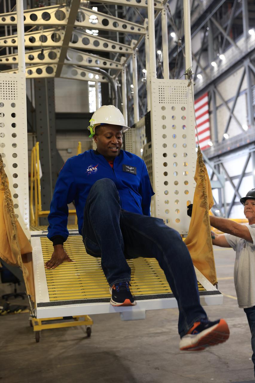 NASA astronaut Andre Douglas, Artemis II backup crew member practices climbing out of an emergency egress basket inside the Vehicle Assembly Building at NASA’s Kennedy Space Center in Florida on Thursday, Feb. 27, 2025. The baskets, similar to gondolas on ski lifts, are used in the case of a pad abort emergency to enable astronauts and other pad personnel a way to quickly escape away from the mobile launcher to the base of the pad and where waiting emergency transport vehicles will then drive them away. For Artemis II, four astronauts will venture around the Moon, the first crewed mission on NASA’s path to establishing a long-term presence for science and exploration through Artemis.