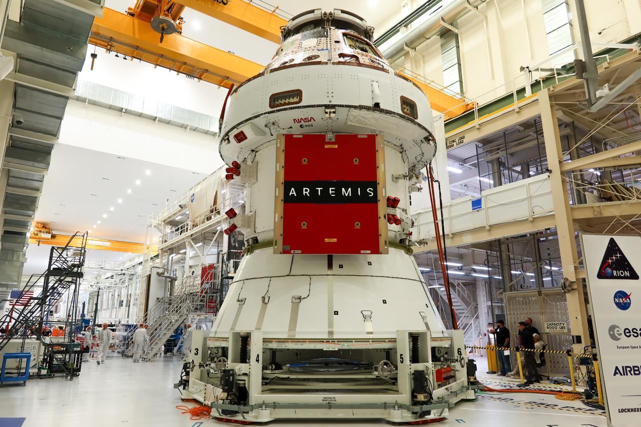 Technicians install four solar array wings on NASA’s Artemis II Orion spacecraft inside the Neil A. Armstrong Operations and Checkout Building at NASA’s Kennedy Space Center in Florida on Monday, March 3, 2025. Each solar array is nearly 23 feet long and can turn on two axes to remain aligned with the Sun for maximum power. Orion’s solar arrays, manufactured and installed by ESA (European Space Agency) and its contractor Airbus, will deliver power to the service module that provides propulsion, thermal control, and electrical power to the spacecraft, as well as air and water for the crew.