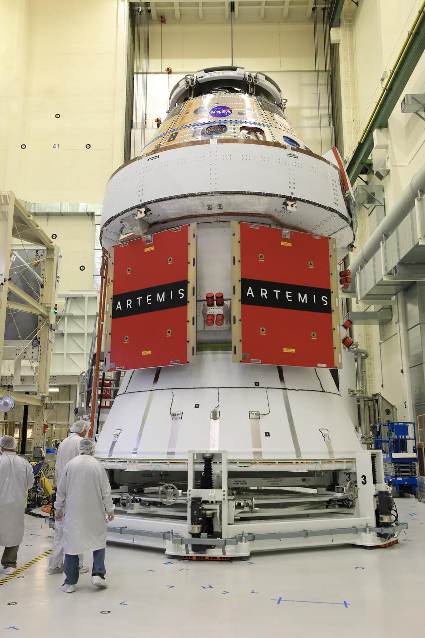 Technicians install four solar array wings on NASA’s Artemis II Orion spacecraft inside the Neil A. Armstrong Operations and Checkout Building at NASA’s Kennedy Space Center in Florida on Monday, March 3, 2025. Each solar array is nearly 23 feet long and can turn on two axes to remain aligned with the Sun for maximum power. Orion’s solar arrays, manufactured and installed by ESA (European Space Agency) and its contractor Airbus, will deliver power to the service module that provides propulsion, thermal control, and electrical power to the spacecraft, as well as air and water for the crew.