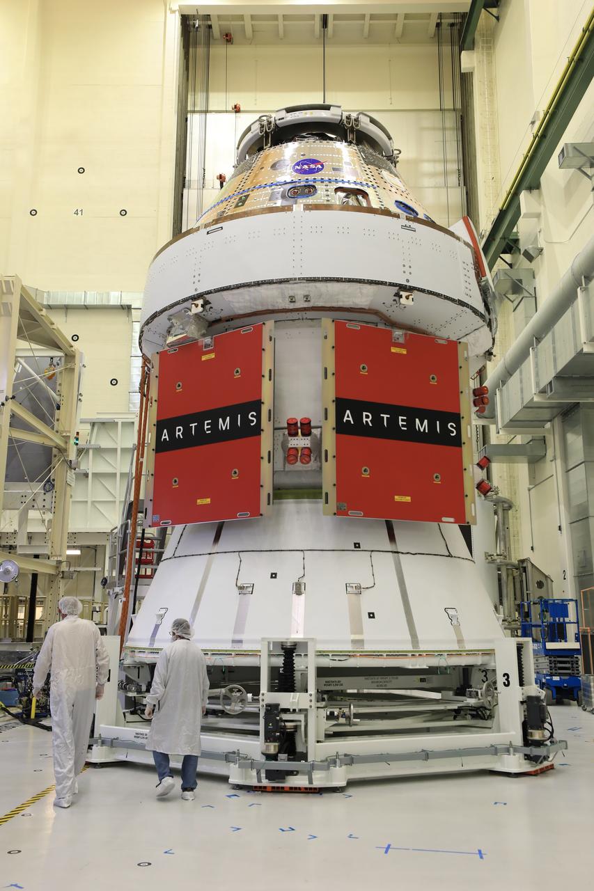 Technicians install four solar array wings on NASA’s Artemis II Orion spacecraft inside the Neil A. Armstrong Operations and Checkout Building at NASA’s Kennedy Space Center in Florida on Monday, March 3, 2025. Each solar array is nearly 23 feet long and can turn on two axes to remain aligned with the Sun for maximum power. Orion’s solar arrays, manufactured and installed by ESA (European Space Agency) and its contractor Airbus, will deliver power to the service module that provides propulsion, thermal control, and electrical power to the spacecraft, as well as air and water for the crew.