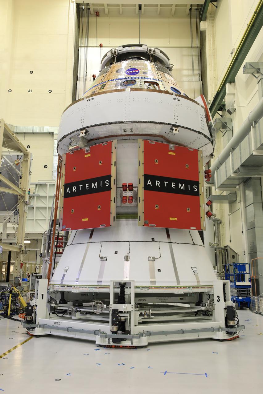 Technicians install four solar array wings on NASA’s Artemis II Orion spacecraft inside the Neil A. Armstrong Operations and Checkout Building at NASA’s Kennedy Space Center in Florida on Monday, March 3, 2025. Each solar array is nearly 23 feet long and can turn on two axes to remain aligned with the Sun for maximum power. Orion’s solar arrays, manufactured and installed by ESA (European Space Agency) and its contractor Airbus, will deliver power to the service module that provides propulsion, thermal control, and electrical power to the spacecraft, as well as air and water for the crew.