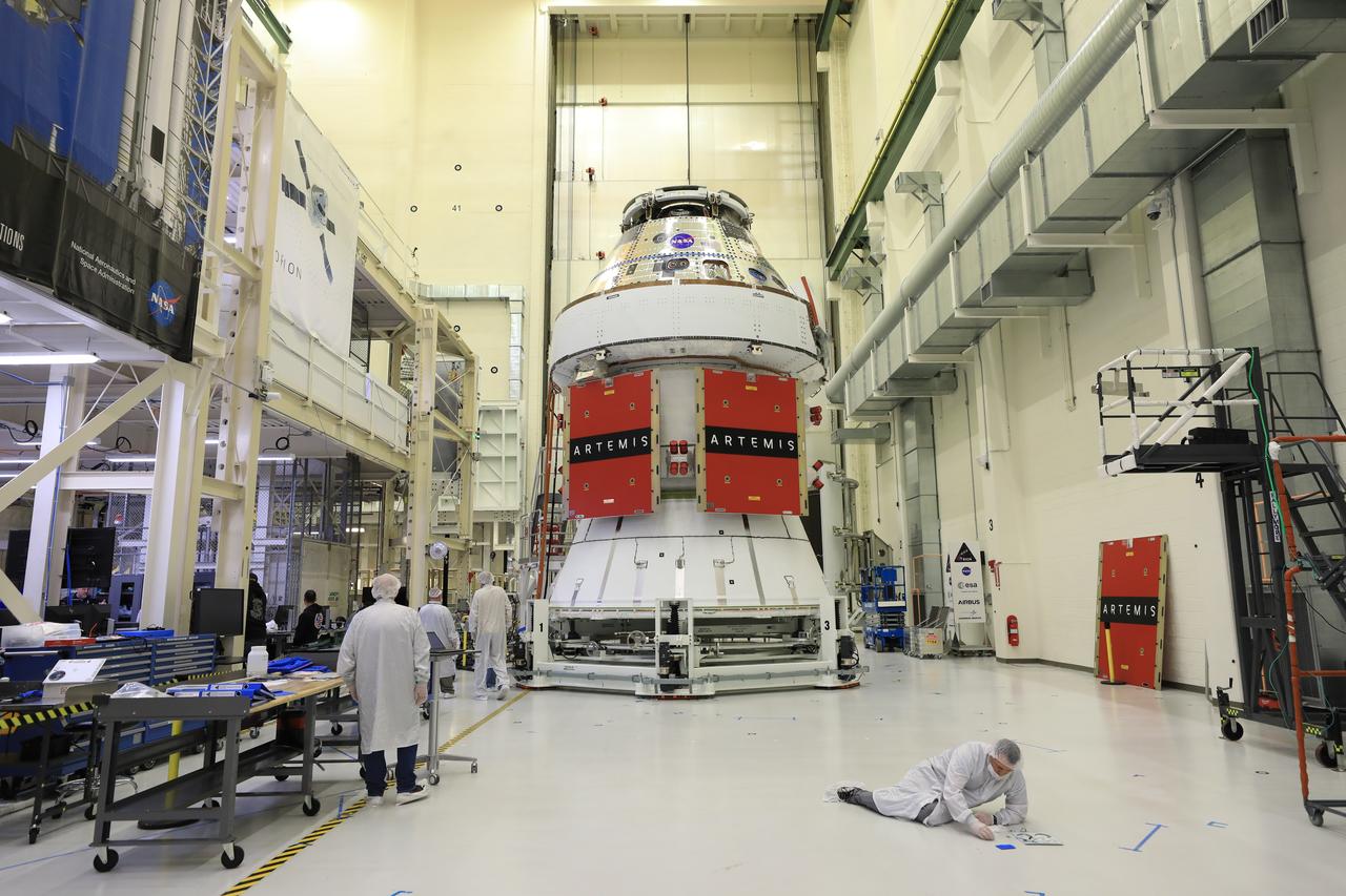 Technicians install four solar array wings on NASA’s Artemis II Orion spacecraft inside the Neil A. Armstrong Operations and Checkout Building at NASA’s Kennedy Space Center in Florida on Monday, March 3, 2025. Each solar array is nearly 23 feet long and can turn on two axes to remain aligned with the Sun for maximum power. Orion’s solar arrays, manufactured and installed by ESA (European Space Agency) and its contractor Airbus, will deliver power to the service module that provides propulsion, thermal control, and electrical power to the spacecraft, as well as air and water for the crew.