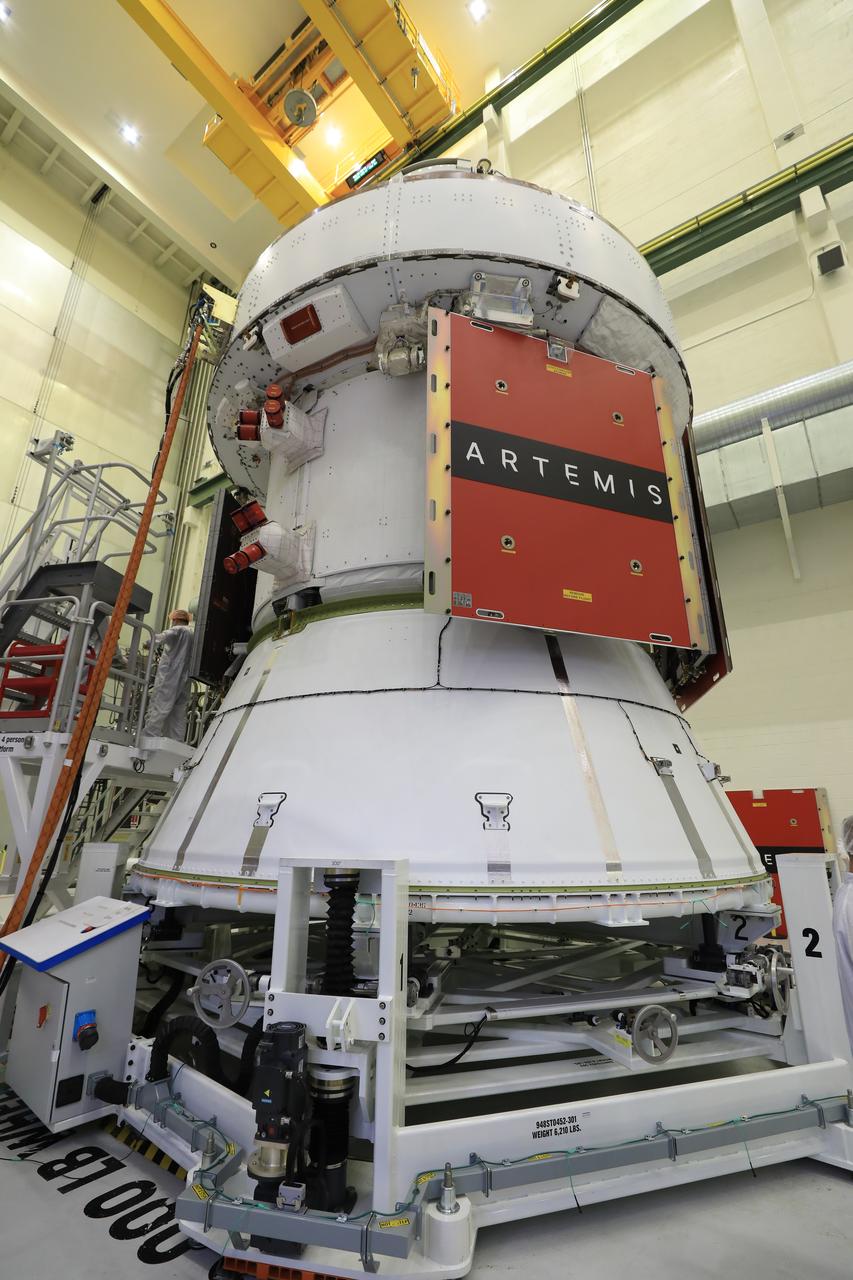 Technicians install four solar array wings on NASA’s Artemis II Orion spacecraft inside the Neil A. Armstrong Operations and Checkout Building at NASA’s Kennedy Space Center in Florida on Monday, March 3, 2025. Each solar array is nearly 23 feet long and can turn on two axes to remain aligned with the Sun for maximum power. Orion’s solar arrays, manufactured and installed by ESA (European Space Agency) and its contractor Airbus, will deliver power to the service module that provides propulsion, thermal control, and electrical power to the spacecraft, as well as air and water for the crew.