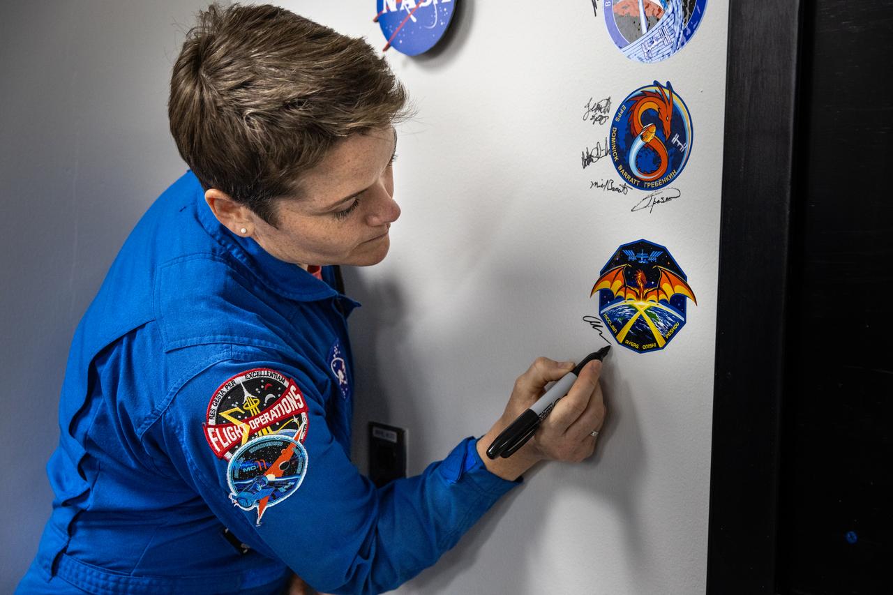 NASA astronaut Anne McClain signs her name inside the Astronaut Crew Quarters in the Neil A. Armstrong Operations and Checkout Building at NASA’s Kennedy Space Center in Florida on Friday, March 7, 2025, ahead of NASA’s SpaceX Crew-10 mission. Crew-10 is the 10th crew rotation mission of the SpaceX Dragon spacecraft and Falcon 9 rocket that will send McClain and fellow NASA astronaut Nichole Ayers, along with JAXA (Japan Aerospace Exploration Agency) astronaut Takuya Onishi and Roscosmos cosmonaut Kirill Peskov to the International Space Station as part of the agency’s Commercial Crew Program. The mission is scheduled to launch no earlier than 7:48 p.m. EDT on Wednesday, March 12, 2025, from NASA Kennedy’s Launch Complex 39A.