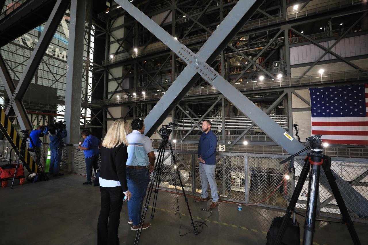 Members of the media get an up-close look at the integrated twin SLS (Space Launch System) solid rocket boosters for Artemis II inside the Vehicle Assembly Building at NASA’s Kennedy Space Center in Florida during Artemis Media Day on Friday, March 7, 2025. The twin solid boosters will help support the remaining rocket components and the Orion spacecraft during final assembly of the Artemis II Moon rocket and provide more than 75 percent of the total SLS thrust during liftoff from NASA Kennedy’s Launch Pad 39B.
