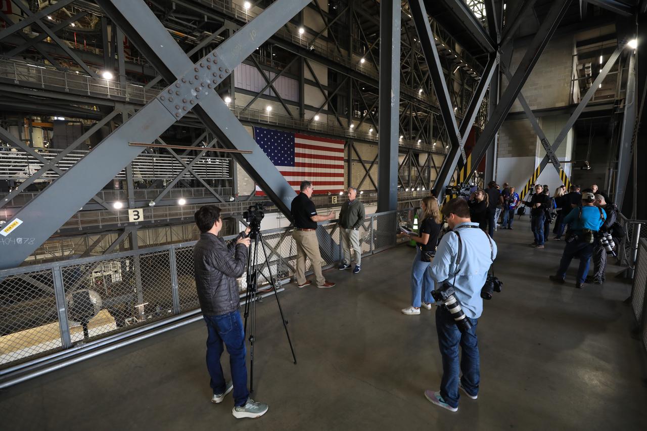 Members of the media get an up-close look at the integrated twin SLS (Space Launch System) solid rocket boosters for Artemis II inside the Vehicle Assembly Building at NASA’s Kennedy Space Center in Florida during Artemis Media Day on Friday, March 7, 2025. The twin solid boosters will help support the remaining rocket components and the Orion spacecraft during final assembly of the Artemis II Moon rocket and provide more than 75 percent of the total SLS thrust during liftoff from NASA Kennedy’s Launch Pad 39B.