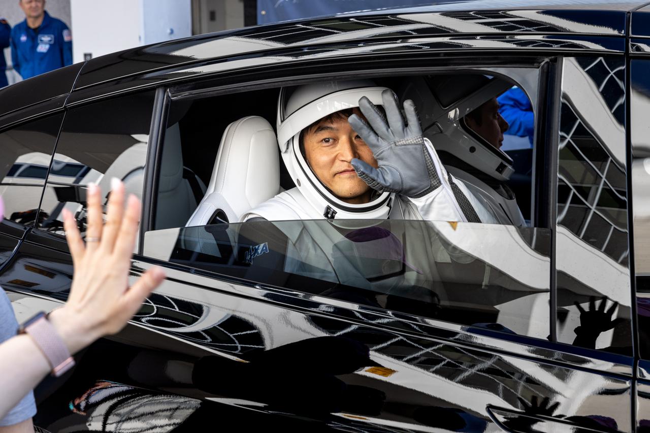 JAXA (Japan Aerospace Exploration Agency) astronaut Takuya Onishi waves from the convoy carrying NASA’s SpaceX Crew-10 from the Neil A. Armstrong Operations and Checkout Building at the agency’s Kennedy Space Center in Florida to nearby Launch Complex 39A ahead of launch on Wednesday, March 12, 2025. NASA astronauts Anne McClain and Nichole Ayers, along with Onishi and Roscosmos cosmonaut Kirill Peskov are scheduled to lift off aboard SpaceX’s Dragon spacecraft and Falcon 9 rocket at 7:48 p.m. EDT. Crew-10 is the 10th crew rotation mission with SpaceX to the space station as part of the agency’s Commercial Crew Program.