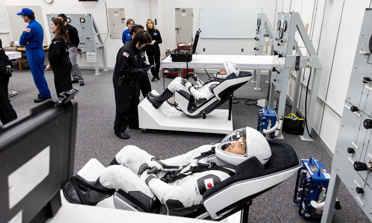 JAXA (Japan Aerospace Exploration Agency) astronaut Takuya Onishi (front) and Roscosmos cosmonaut Kirill Peskov (rear) are photographed in their SpaceX spacesuits inside the crew suit-up room in the Neil A. Armstrong Operations and Checkout Building at the agency’s Kennedy Space Center in Florida ahead of launch of NASA’s SpaceX Crew-10 mission on Wednesday, March 12, 2025. NASA astronauts Anne McClain and Nichole Ayers, along with JAXA (Japan Aerospace Exploration Agency) astronaut Takuya Onishi and Peskov are scheduled to lift off aboard SpaceX’s Dragon spacecraft and Falcon 9 rocket at 7:48 p.m. EDT, from Launch Complex 39A at NASA Kennedy. Crew-10 is the 10th crew rotation mission with SpaceX to the space station as part of the agency’s Commercial Crew Program.