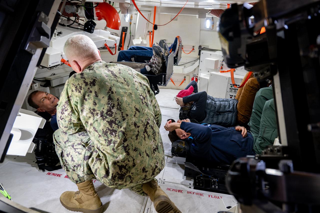 Vice Adm. John F. G. Wade, commander of U.S. 3rd Fleet, speaks with NASA astronaut Stan Love inside an Orion crew module test article in the well deck of amphibious transport dock USS Somerset (LPD 25) ahead of NASA Underway Recovery Test 12 on Naval Base San Diego, March 25, 2025. In preparation for NASA's Artemis II crewed mission, which will send four astronauts around the Moon and beyond in the Orion spacecraft, NASA and the Department of Defense will conduct a series of tests to demonstrate and evaluate the processes, procedures, and hardware used in recovery operations for crewed lunar missions.