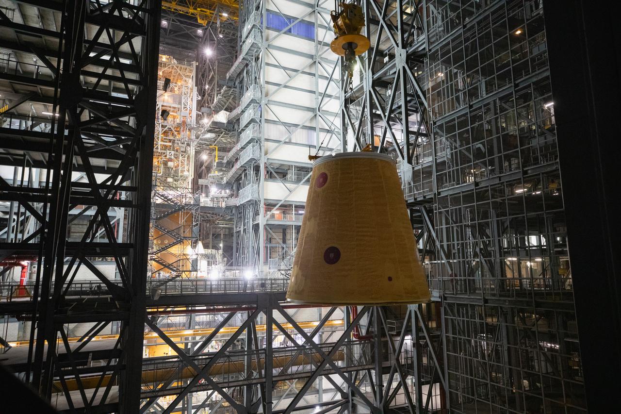 A massive crane lifts the launch vehicle stage adapter 250 feet into the air on Thursday, April 3, 2025, to prepare integration onto the SLS (Space Launch System) core stage in High Bay 3 inside the Vehicle Assembly Building at NASA’s Kennedy Space Center in Florida. During launch and ascent, the launch vehicle stage adapter provides structural support and protects avionics and electrical devices within the upper stage from extreme vibrations and acoustic conditions. The Artemis II test flight will take a crew of four astronauts on a 10-day journey around the Moon, helping confirm the foundational systems and hardware needed for human deep space exploration. 