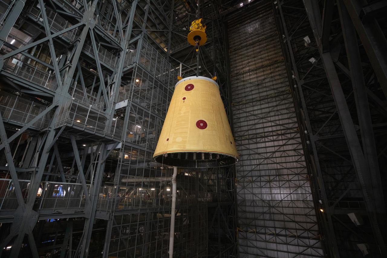 A massive crane lifts the launch vehicle stage adapter 250 feet into the air on Thursday, April 3, 2025, to prepare integration onto the SLS (Space Launch System) core stage in High Bay 3 inside the Vehicle Assembly Building at NASA’s Kennedy Space Center in Florida. During launch and ascent, the launch vehicle stage adapter provides structural support and protects avionics and electrical devices within the upper stage from extreme vibrations and acoustic conditions. The Artemis II test flight will take a crew of four astronauts on a 10-day journey around the Moon, helping confirm the foundational systems and hardware needed for human deep space exploration. 