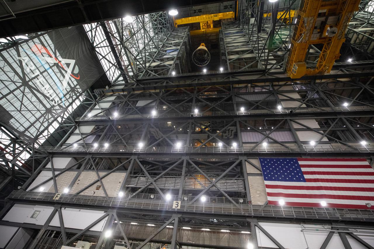 A massive crane lifts the launch vehicle stage adapter 250 feet into the air on Thursday, April 3, 2025, to prepare integration onto the SLS (Space Launch System) core stage in High Bay 3 inside the Vehicle Assembly Building at NASA’s Kennedy Space Center in Florida. During launch and ascent, the launch vehicle stage adapter provides structural support and protects avionics and electrical devices within the upper stage from extreme vibrations and acoustic conditions. The Artemis II test flight will take a crew of four astronauts on a 10-day journey around the Moon, helping confirm the foundational systems and hardware needed for human deep space exploration. 