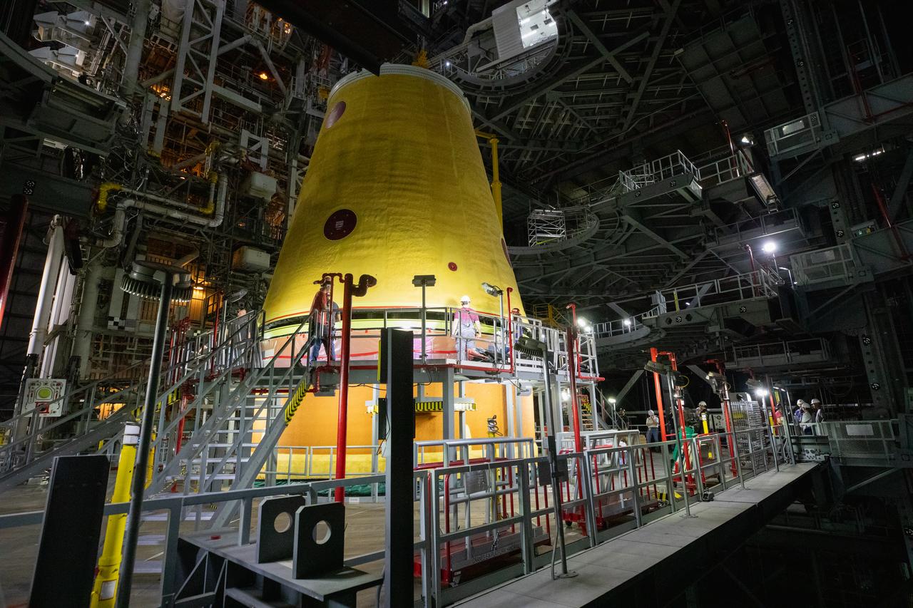 A massive crane lowers the launch vehicle stage adapter onto the SLS (Space Launch System) core stage on Thursday, April 3, 2025, in High Bay 3 inside the Vehicle Assembly Building at NASA’s Kennedy Space Center in Florida. During launch and ascent, the launch vehicle stage adapter provides structural support and protects avionics and electrical devices within the upper stage from extreme vibrations and acoustic conditions. The Artemis II test flight will take a crew of four astronauts on a 10-day journey around the Moon, helping confirm the foundational systems and hardware needed for human deep space exploration.