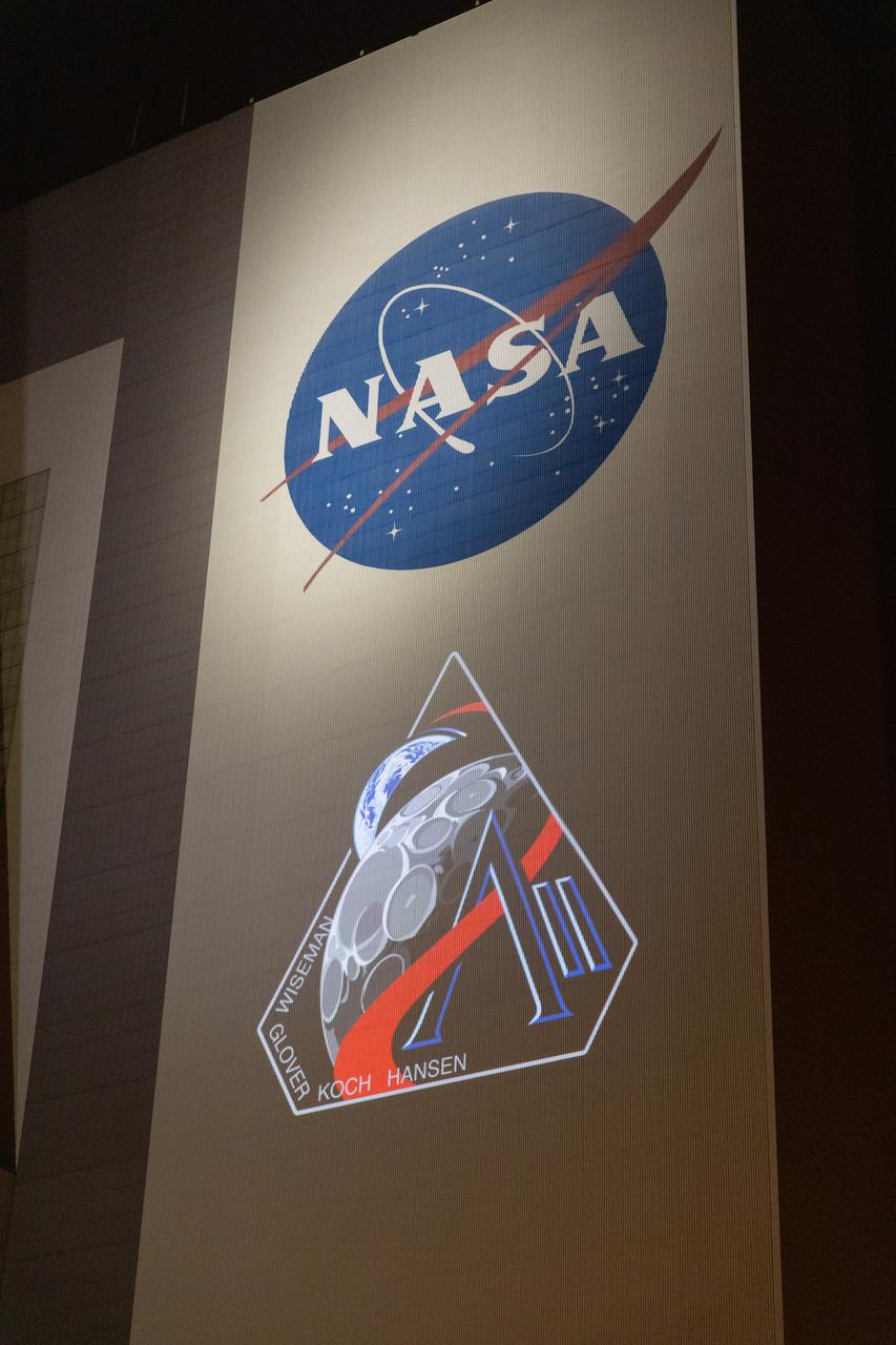 The official Artemis II mission crew insignia is projected on the exterior of the Vehicle Assembly Building at NASA’s Kennedy Space Center in Florida on Friday, April 4, 2025. The patch designates the mission as “AII,” signifying not only the second major flight of the Artemis campaign, but also an endeavor of discovery that seeks to explore for all and by all. Framed in Apollo 8’s famous Earthrise photo, the scene of the Earth and the Moon represents the dual nature of human spaceflight, both equally compelling: The Moon represents our exploration destination, focused on discovery of the unknown. The Earth represents home, focused on the perspective we gain when we look back at our shared planet and learn what it is to be uniquely human. The orbit around Earth highlights the ongoing exploration missions that have enabled Artemis to set sights on a long-term presence on the Moon and soon, Mars.