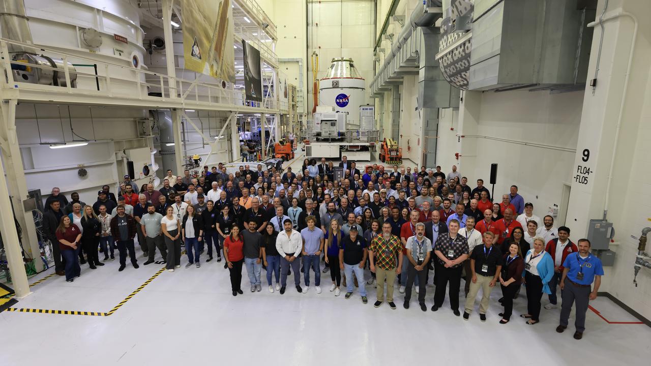 Teams from NASA and Lockheed Martin pose for a photo in front of NASA’s Artemis II Orion spacecraft, connected to a massive crane ahead atop the agency’s KAMAG transporter inside the Neil A. Operations and Checkout Building at NASA’s Kennedy Space Center in Florida on Friday, May 2, 2025. The spacecraft will be transported to the spaceport’s Multi-Payload Processing Facility to undergo fueling and processing for prelaunch operations. The Artemis II test flight is the first crewed flight under NASA’s Artemis campaign and is another step toward missions on the lunar surface and helping the agency prepare for future human missions to Mars.