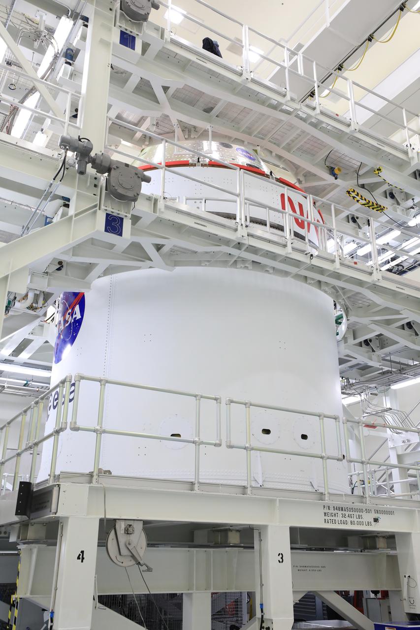 Technicians with NASA’s Exploration Ground Systems Program offload the agency’s Orion spacecraft from the KAMAG transporter to the servicing stand inside the Multi-Payload Processing Facility at Kennedy Space Center in Florida on Sunday, May 4, 2025, to undergo fueling and processing operations for prelaunch operations. The Artemis II test flight is the first crewed flight under NASA’s Artemis campaign and is another step toward missions on the lunar surface and helping the agency prepare for future human missions to Mars.  