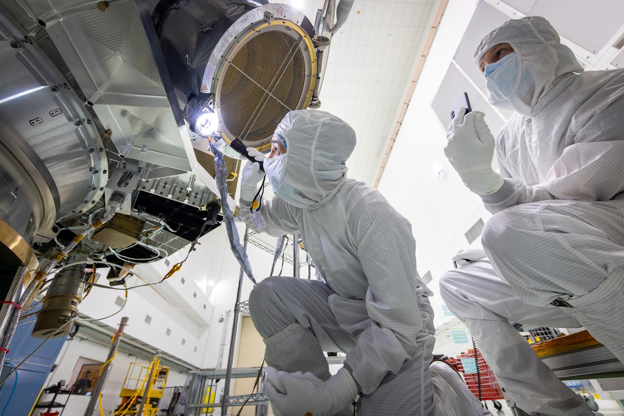 Technicians test the spring-activated door on the Interstellar Dust Experiment (IDEX) instrument of NASA’s IMAP (Interstellar Mapping and Acceleration Probe) observatory inside the high bay at the Astrotech Space Operations Facility near the agency’s Kennedy Space Center in Florida on Tuesday, June 3, 2025. The door will remain closed to protect IDEX from contamination during integration and launch. Once in space, the door will swing open permanently to allow interstellar and interplanetary dust to flow into the instrument for measurement. The IMAP observatory will study how the Sun shapes the boundaries of the heliosphere, the protective bubble around our solar system. Launch is targeted for no earlier than September 2025 aboard a SpaceX Falcon 9 rocket from Launch Complex 39A at NASA Kennedy.