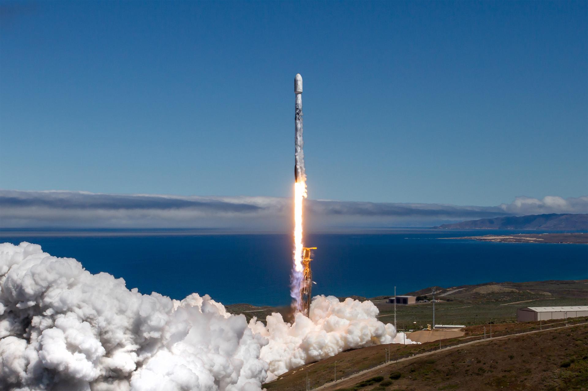Image shows a white and black SpaceX Falcon 9 rocket surrounded by water and clear skies lift off from Space Launch Complex 4 East at Vandenberg Space Force Base in California on Wednesday, July 23, 2025. NASA’s TRACERS (Tandem Reconnection and Cusp Electrodynamics Reconnaissance Satellites) mission  will study magnetic reconnection around Earth — a process in which electrically charged plasmas exchange energy in the atmosphere — to understand how the Sun’s solar wind interacts with the magnetosphere, Earth’s protective magnetic shield. Photo credit: SpaceX