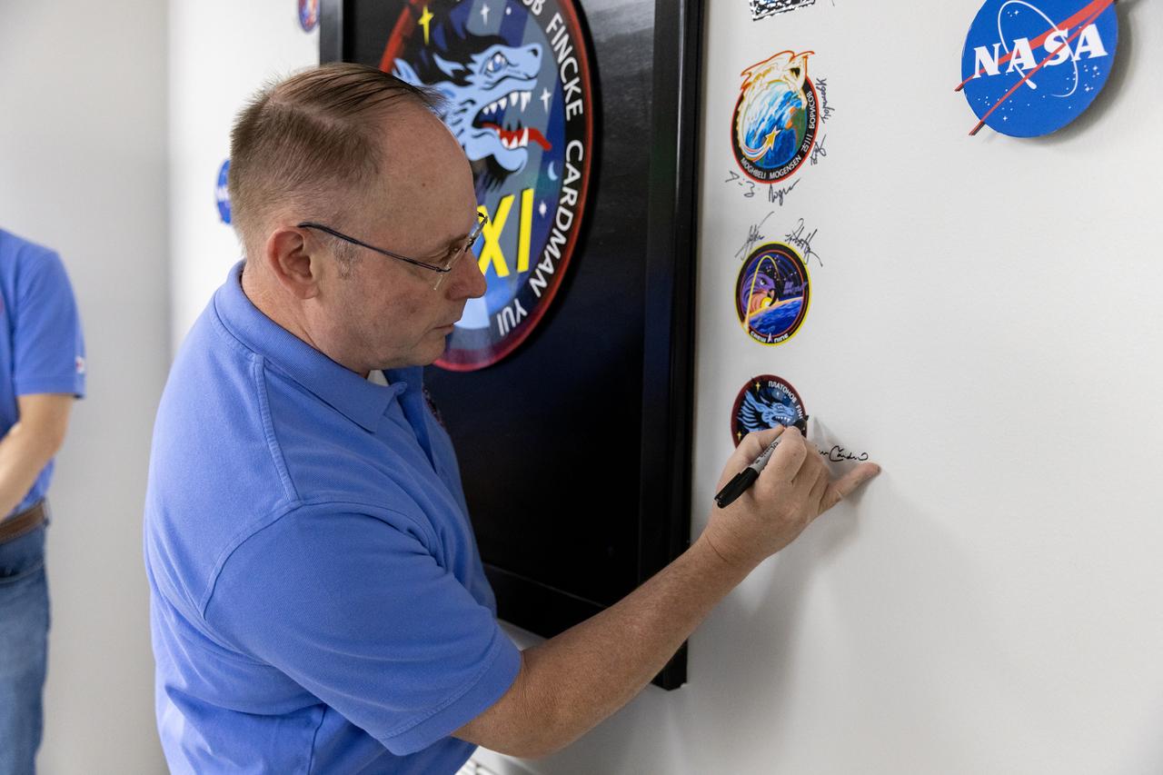 NASA astronaut Mike Fincke signs his name next to NASA’s SpaceX Crew-11 mission logo inside the Astronaut Crew Quarters in the Neil A. Armstrong Operations and Checkout Building at NASA’s Kennedy Space Center in Florida on Monday, July 28, 2025. A SpaceX Dragon spacecraft and Falcon 9 rocket will send NASA astronauts Fincke, Zena Cardman, along with JAXA (Japan Aerospace Exploration Agency) astronaut Kimiya Yui and Roscosmos cosmonaut Oleg Platonov to the International Space Station no earlier than 12:09 p.m. EDT Thursday, July 31, 2025, from NASA Kennedy’s Launch Complex 39A.
