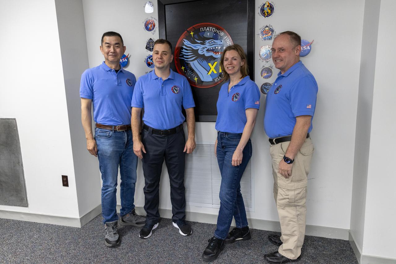 From right to left, NASA astronauts Mike Fincke and Zena Cardman, along with Roscosmos cosmonaut Oleg Platonov and JAXA (Japan Aerospace Exploration Agency) astronaut Kimiya Yui, pose next to their mission patch logo inside the Astronaut Crew Quarters in the Neil A. Armstrong Operations and Checkout Building at NASA’s Kennedy Space Center in Florida on Monday, July 28, 2025. NASA’s SpaceX Crew-11 crew members will launch aboard a SpaceX Dragon spacecraft and Falcon 9 to the International Space Station no earlier than 12:09 p.m. EDT on Thursday, July 31, 2025, from NASA Kennedy’s Launch Complex 39A.