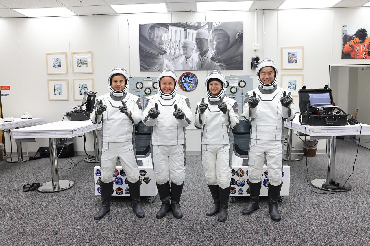 From right to left, NASA’s SpaceX Crew-11 crew members JAXA (Japan Aerospace Exploration Agency) astronaut Kimiya Yui, along with NASA astronauts Zena Cardman and Mike Fincke, as well as Roscosmos cosmonaut Oleg Platonov pose for a photo inside the crew suit-up room in the Neil A. Armstrong Operations and Checkout Building at the agency’s Kennedy Space Center in Florida during a countdown dress rehearsal on Monday, July 28, 2025. The crew will launch to the International Space Station aboard SpaceX’s Dragon spacecraft and Falcon 9 rocket at 12:09 p.m. EDT on Thursday, July 31, 2025, from NASA Kennedy’s Launch Complex 39A. 
