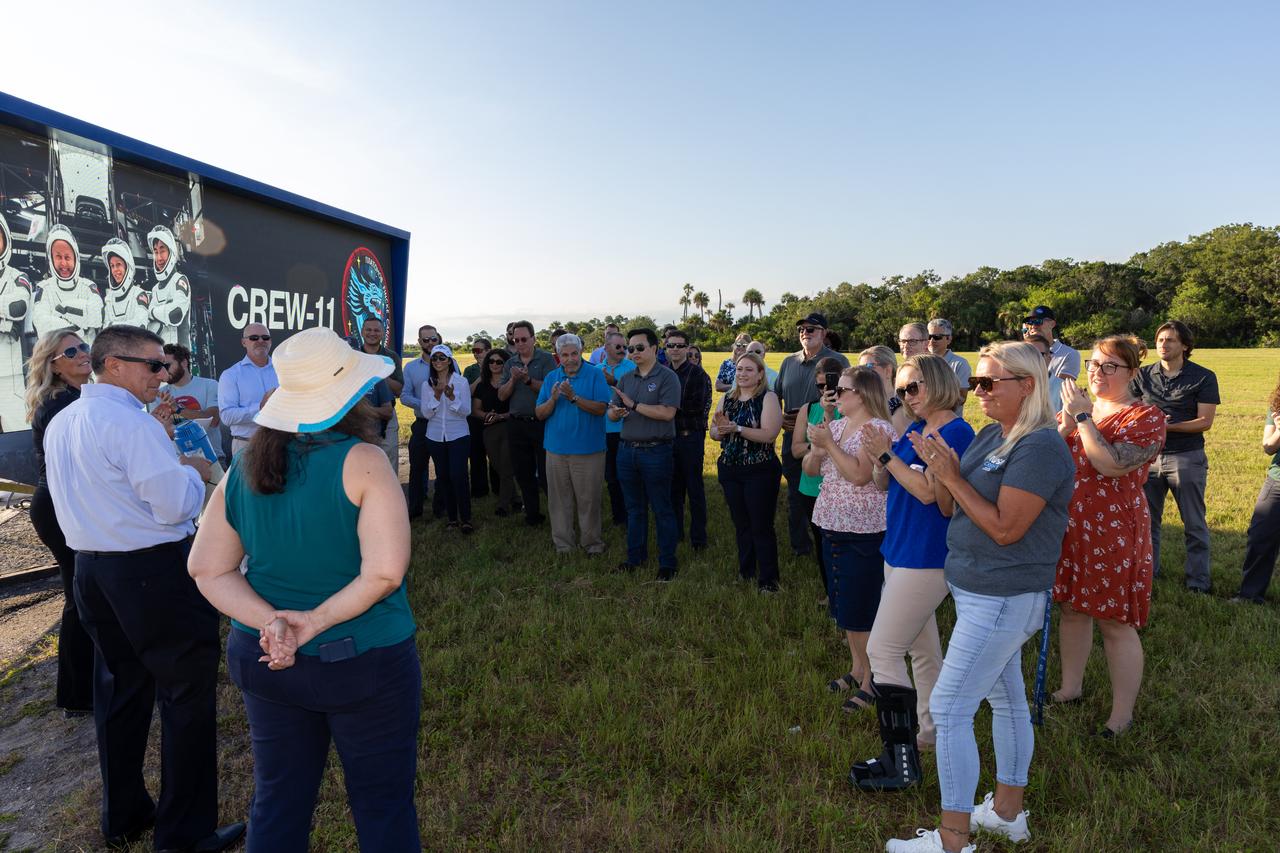 NASA’s Commercial Crew Program employees gather near the countdown clock following the raising of the agency’s SpaceX Crew-11 mission flag at the NASA News Center at the agency’s Kennedy Space Center in Florida on Wednesday, July 30, 2025. The Crew-11 mission will send NASA astronauts Zena Cardman and Mike Fincke, along with JAXA (Japan Aerospace Exploration Agency) astronaut Kimiya Yui and Roscosmos cosmonaut Oleg Platonov to the International Space Station aboard SpaceX’s Dragon spacecraft and Falcon 9 at 12:09 p.m. EDT on Thursday, July 31, 2025, from NASA Kennedy’s Launch Complex 39A.  