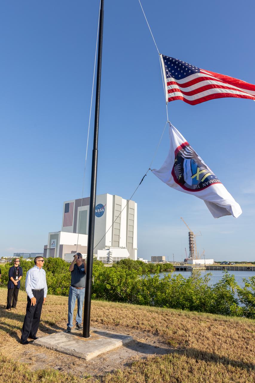 NASA’s Commercial Crew Program employees raise the agency’s SpaceX Crew-11 mission flag near the countdown clock at the NASA News Center at the agency’s Kennedy Space Center in Florida on Wednesday, July 30, 2025. The Crew-11 mission will send NASA astronauts Zena Cardman and Mike Fincke, along with JAXA (Japan Aerospace Exploration Agency) astronaut Kimiya Yui and Roscosmos cosmonaut Oleg Platonov to the International Space Station aboard SpaceX’s Dragon spacecraft and Falcon 9 at 12:09 p.m. EDT on Thursday, July 31, 2025, from NASA Kennedy’s Launch Complex 39A.  