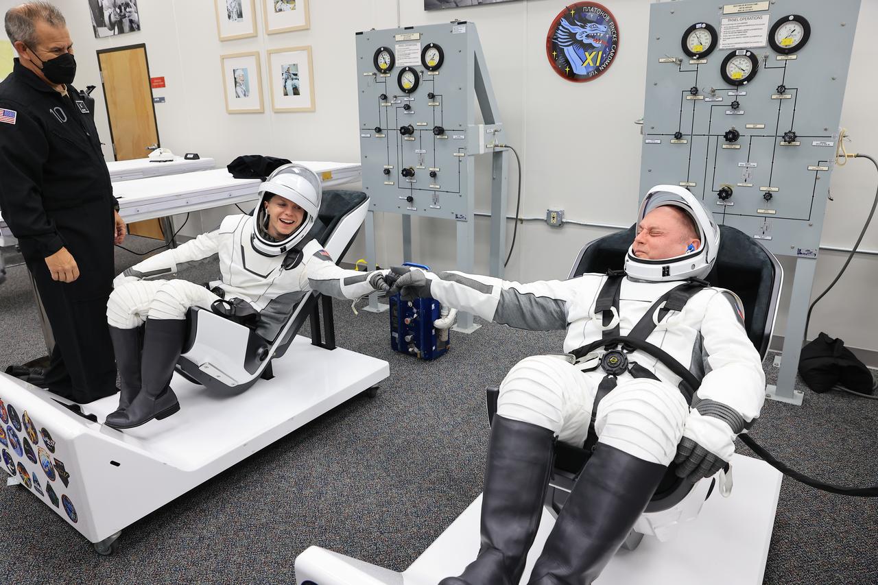 From left, NASA astronauts Zena Cardman and Mike Fincke give each other a “fist pump” during leak checks for their SpaceX spacesuit inside the crew suit-up room in the Neil A. Armstrong Operations and Checkout Building at the agency’s Kennedy Space Center in Florida during the second launch attempt of NASA’s SpaceX Crew-11 mission to the International Space Station on Friday, Aug. 1, 2025. Cardman and Fincke, along with JAXA (Japan Aerospace Exploration Agency) astronaut Kimiya Yui and Roscosmos cosmonaut Oleg Platonov, are scheduled to lift off aboard SpaceX’s Dragon spacecraft and Falcon 9 rocket at 11:43 a.m. EDT, from Launch Complex 39A at NASA Kennedy.