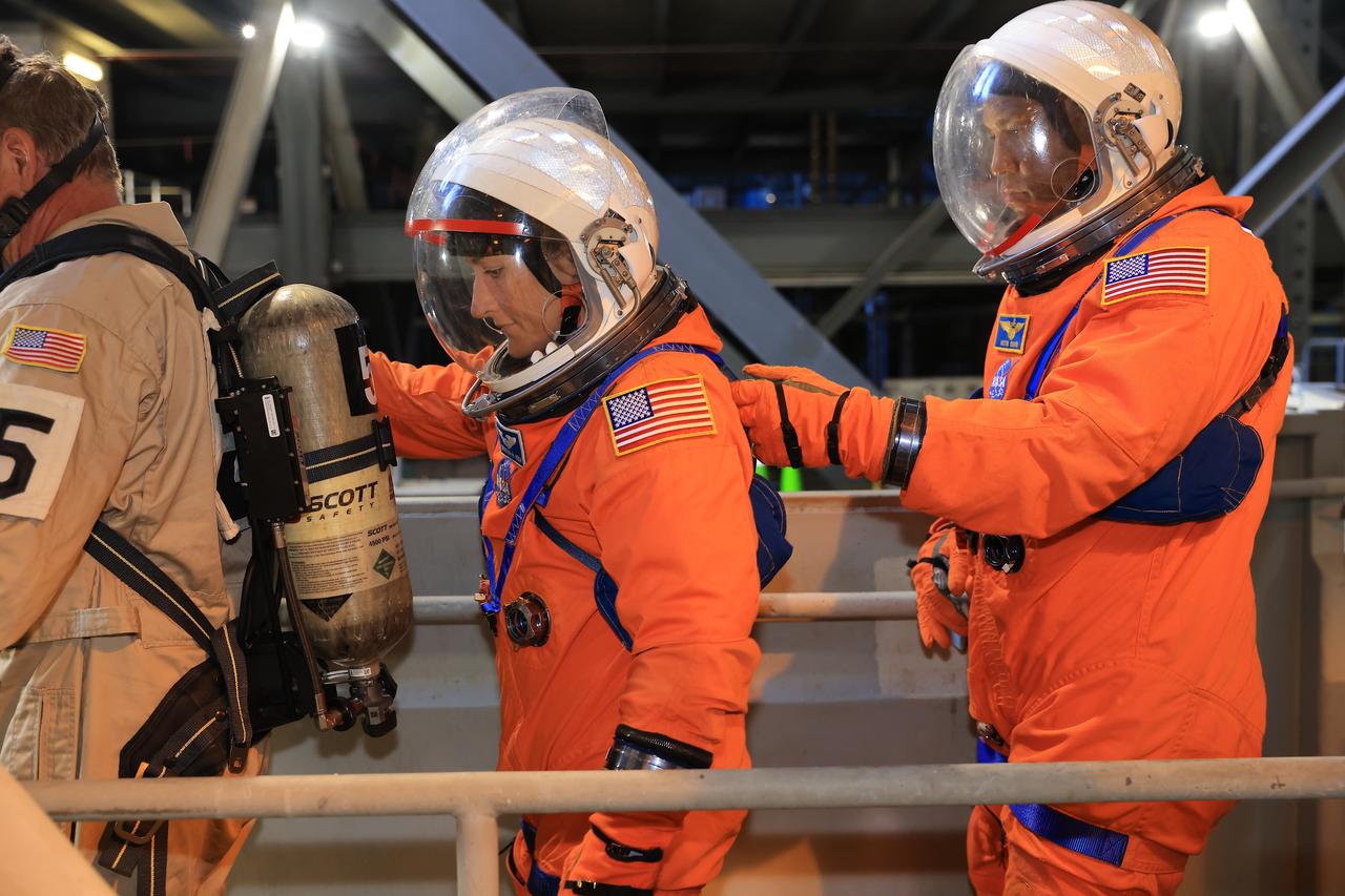 NASA astronauts Christina Koch, Artemis II mission specialist, and Victor Glover, Artemis II pilot, walk on the crew access arm of the mobile launcher in the Vehicle Assembly Building at NASA’s Kennedy Space Center in Florida on Tuesday, Aug. 12, 2025. During a two-day operation, the Artemis II team practiced night-run demonstrations of different launch day scenarios like suit-up operations, walk-out, and arriving at the launch pad for the Artemis II test flight. Through the Artemis campaign, NASA will send astronauts to explore the Moon for scientific discovery, economic benefits, and to build the foundation for the first crewed missions to Mars – for the benefit of all.  