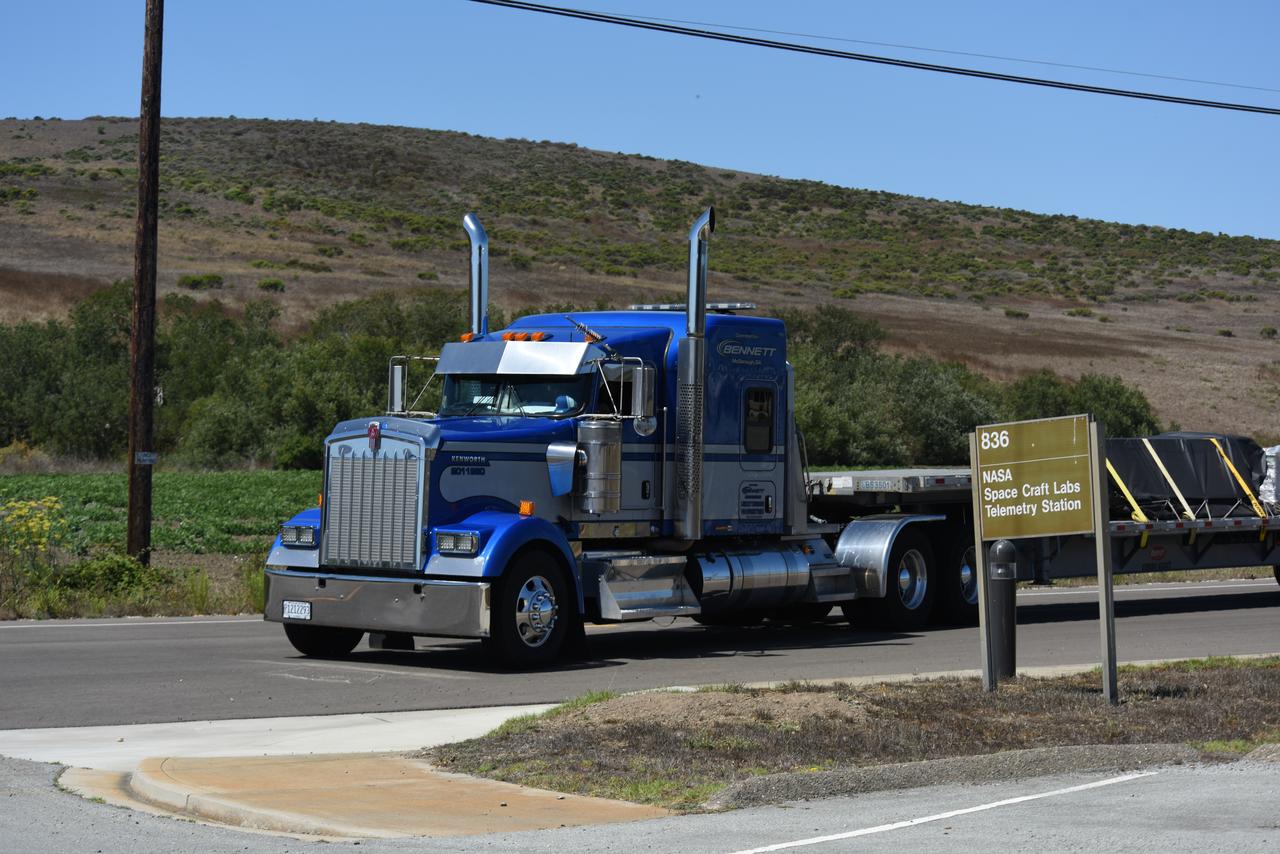 Wrapped in protective coverings, ground support equipment for the Sentinel-6B spacecraft, a collaboration between NASA, ESA (European Space Agency), EUMETSAT (European Organisation for the Exploitation of Meteorological Satellites), and the National Oceanic and Atmospheric Administration (NOAA), arrives by truck to NASA’s Building 836 at Vandenberg Space Force Base in California on Monday, Aug. 18, 2025. The second of two spacecraft that constitutes the Sentinel-6/Jason-CS (Continuity of Service) mission, Sentinel-6B will measure sea surface height and provide crucial information to help improve coastal planning, enabling local and state governments to make informed decisions about protecting coastal infrastructure, real estate, and energy sites. Launch is targeted for no earlier than November on a SpaceX Falcon 9 from Vandenberg.