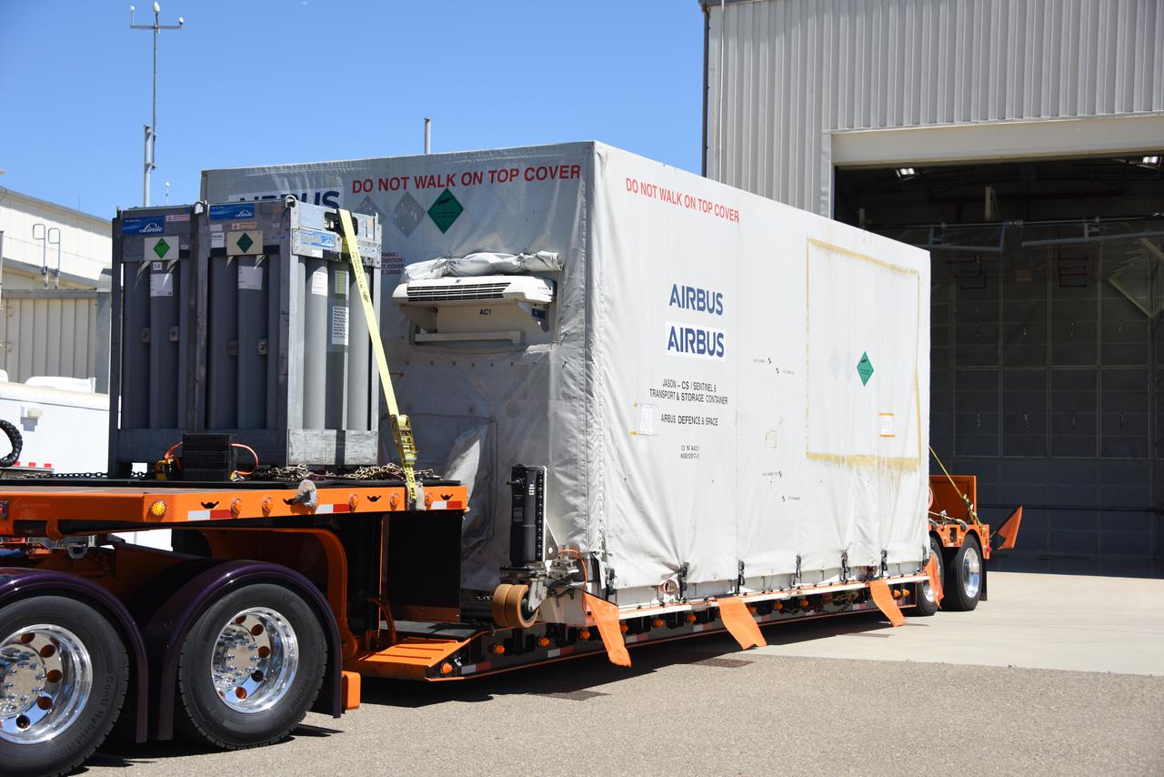 Packed in its shipping container, the Sentinel-6B spacecraft, a collaboration between NASA, ESA (European Space Agency), EUMETSAT (European Organisation for the Exploitation of Meteorological Satellites), and the National Oceanic and Atmospheric Administration (NOAA), arrives by truck at the entrance NASA’s Building 836 at Vandenberg Space Force Base in California on Monday, Aug. 18, 2025. The second of two spacecraft that constitutes the Sentinel-6/Jason-CS (Continuity of Service) mission, Sentinel-6B will measure sea surface height and provide crucial information to help improve coastal planning, enabling local and state governments to make informed decisions about protecting coastal infrastructure, real estate, and energy sites. Launch is targeted for no earlier than November on a SpaceX Falcon 9 from Vandenberg.