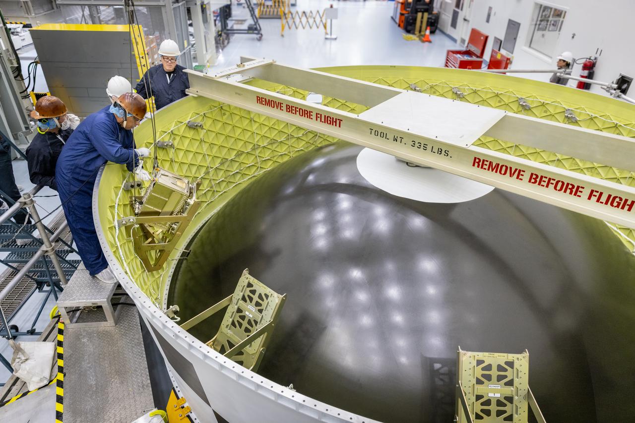 Technicians install the Korea AeroSpace Administration (KASA) K-Rad Cube within the Orion stage adapter inside the Multi-Payload Processing Facility at NASA’s Kennedy Space Center in Florida on Tuesday, Sept. 2, 2025. The K-Rad Cube, about the size of a shoebox, is one of the CubeSats slated to fly on NASA’s Artemis II test flight in 2026. Deploying in high Earth orbit from a spacecraft adapter on NASA’s SLS (Space Launch System) rocket after Orion is safely flying on its own with its crew of four astronauts, K-Rad Cube will use a dosimeter made of material designed to mimic human tissue to measure space radiation and assess biological effects at various altitudes across the Van Allen radiation belts, a critical area of research for human presence at the Moon and Mars.